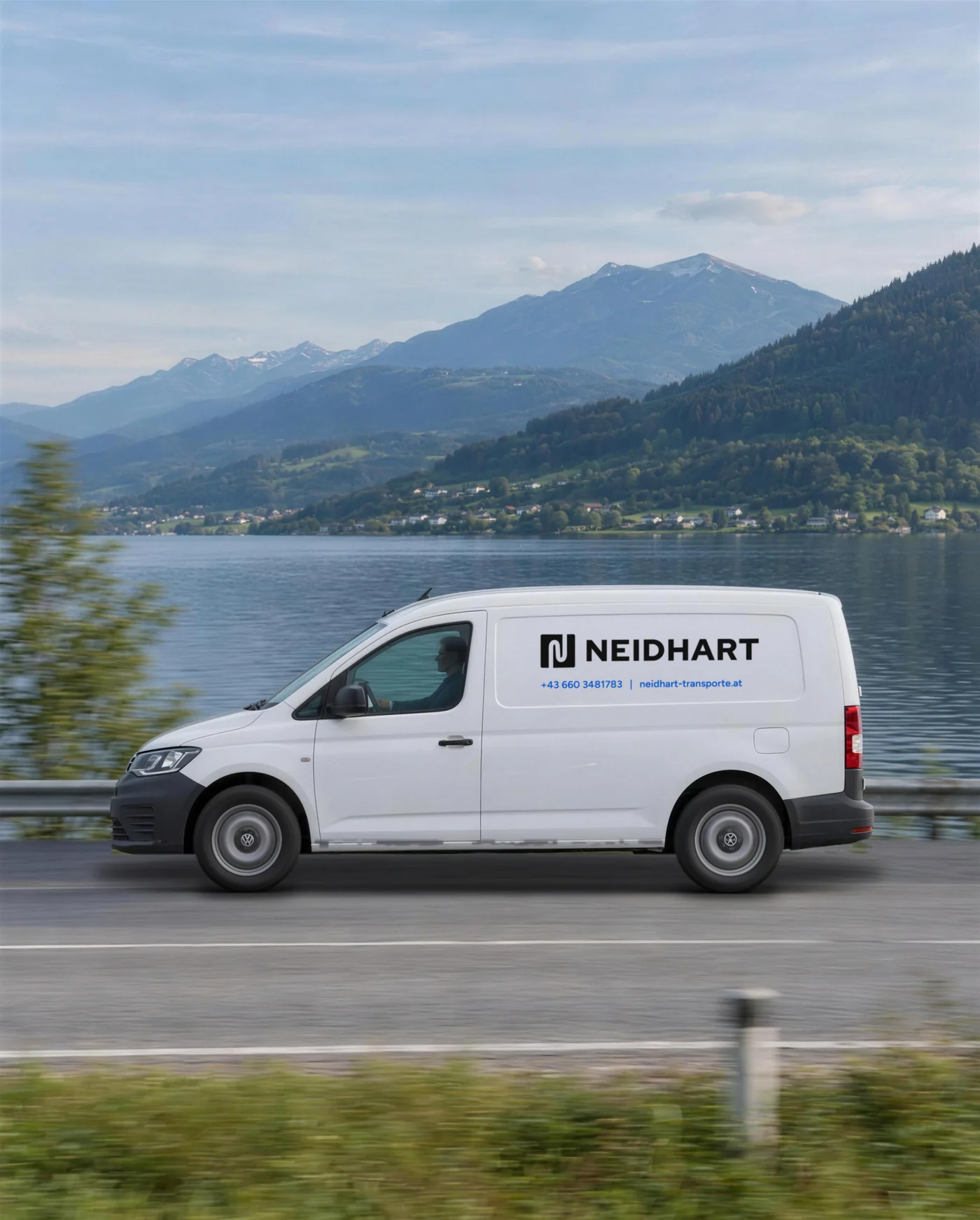 Weißer VW Caddy mit Neidhart Beschriftung auf einer Straße am See in Kärnten